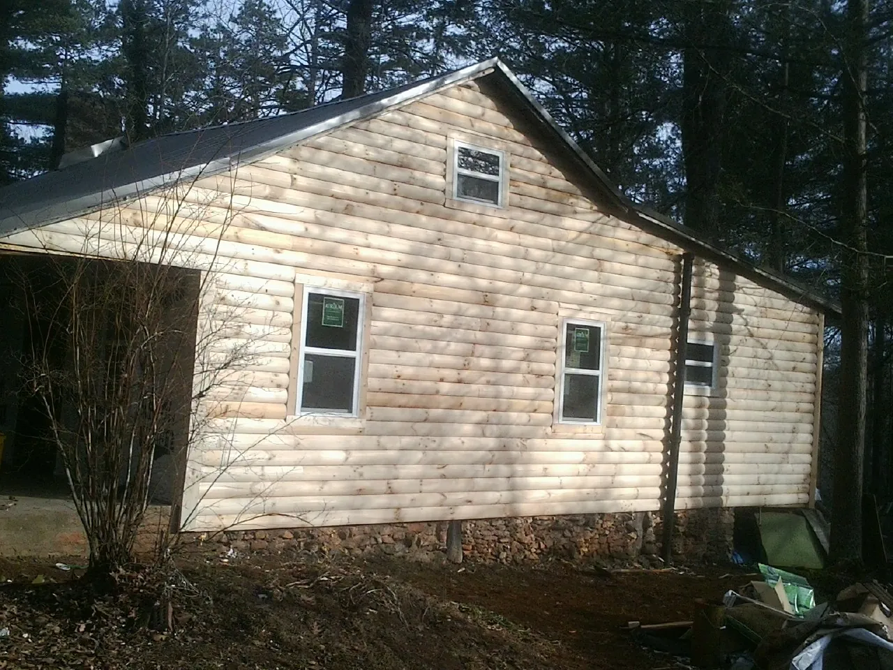 New log siding and dark metal roofing on a gable end in Saxton