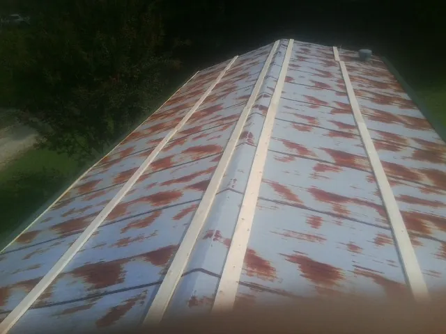 Rusted metal roof panels with new wood purlins before replacement — Storm Damage Roof Repair in Saxton by Roofing Brothers