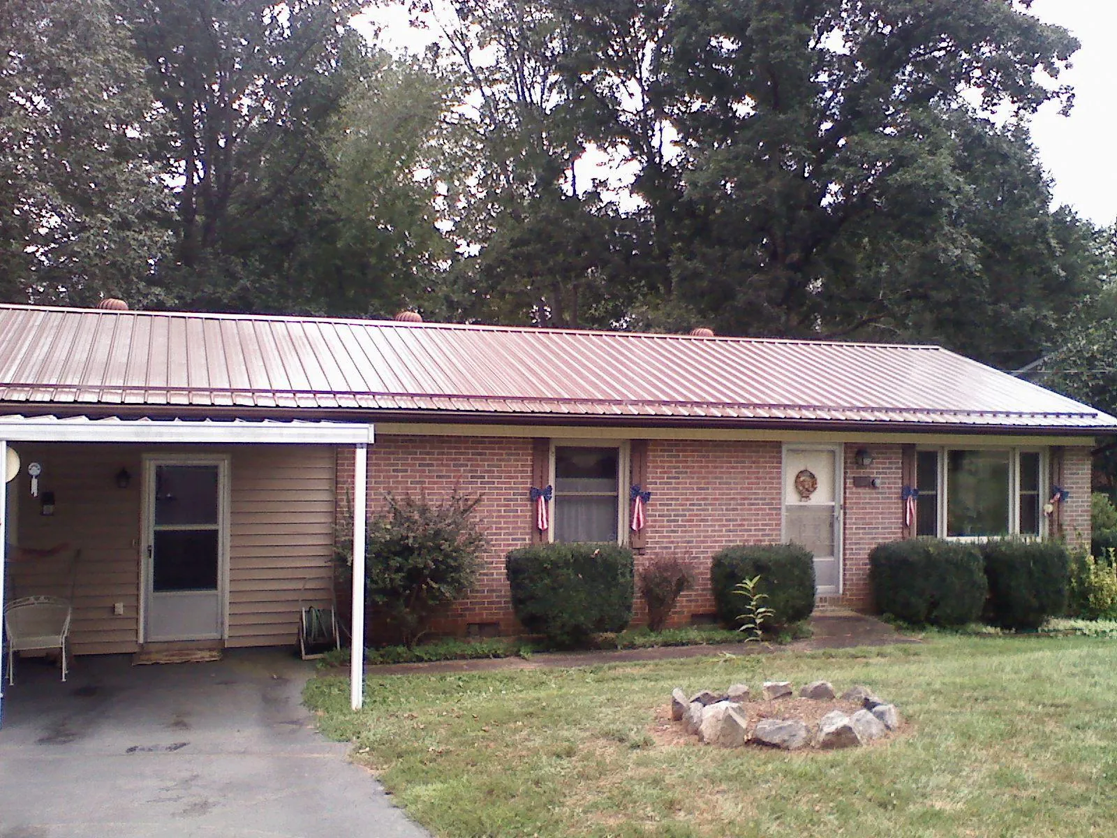 Bronze metal roof and carport on a brick ranch home — Roof Repair work by our crew in Saxton